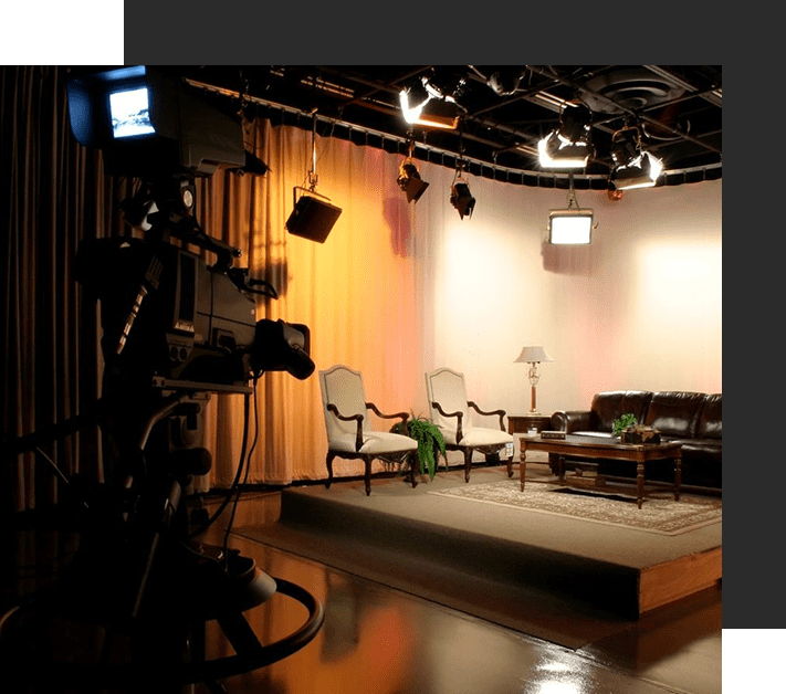 A television set in front of a stage with chairs.