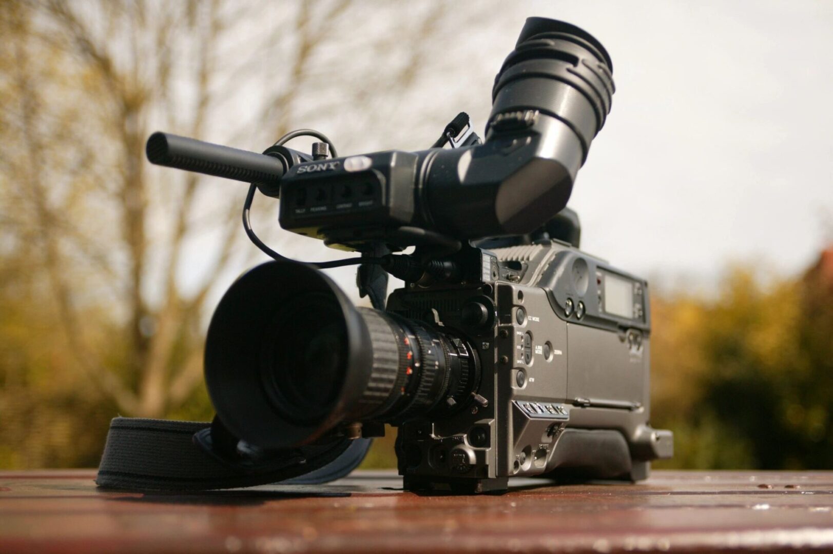 A video camera sitting on top of a wooden table.