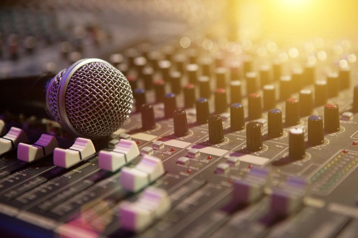 A microphone sitting on top of an audio board.