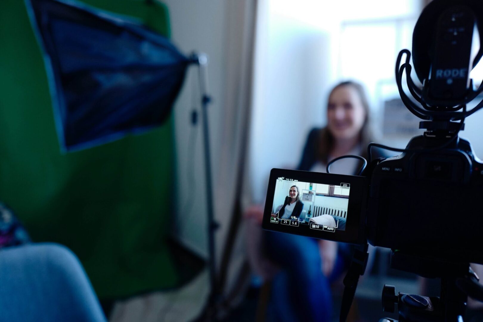 A woman is sitting in front of a camera.